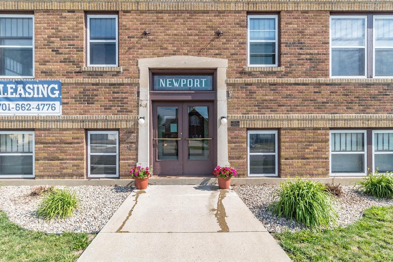 the front of a brick building with a sidewalk in front