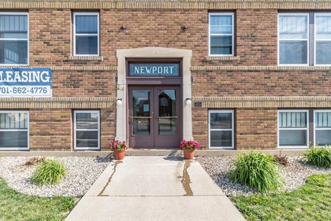the front of a brick building with a sidewalk in front