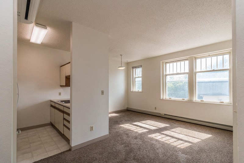 the living room and kitchen of an empty apartment