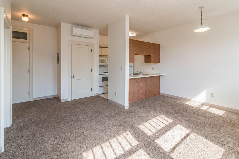 an empty living room and kitchen in an apartment