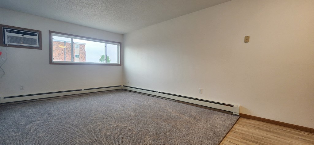 the living room of an empty house with a large window