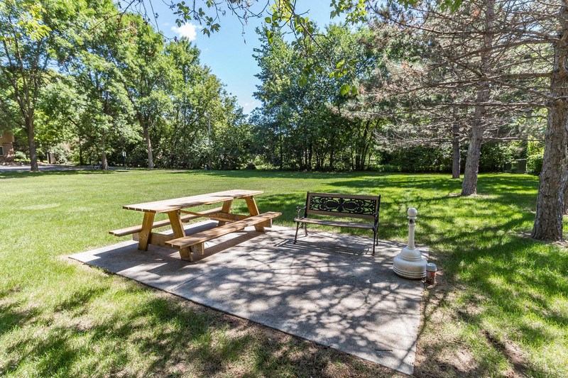a picnic table and a bench in a park