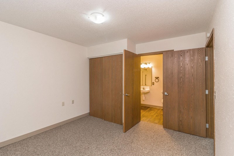 a bedroom with a closet and a door to a bathroom