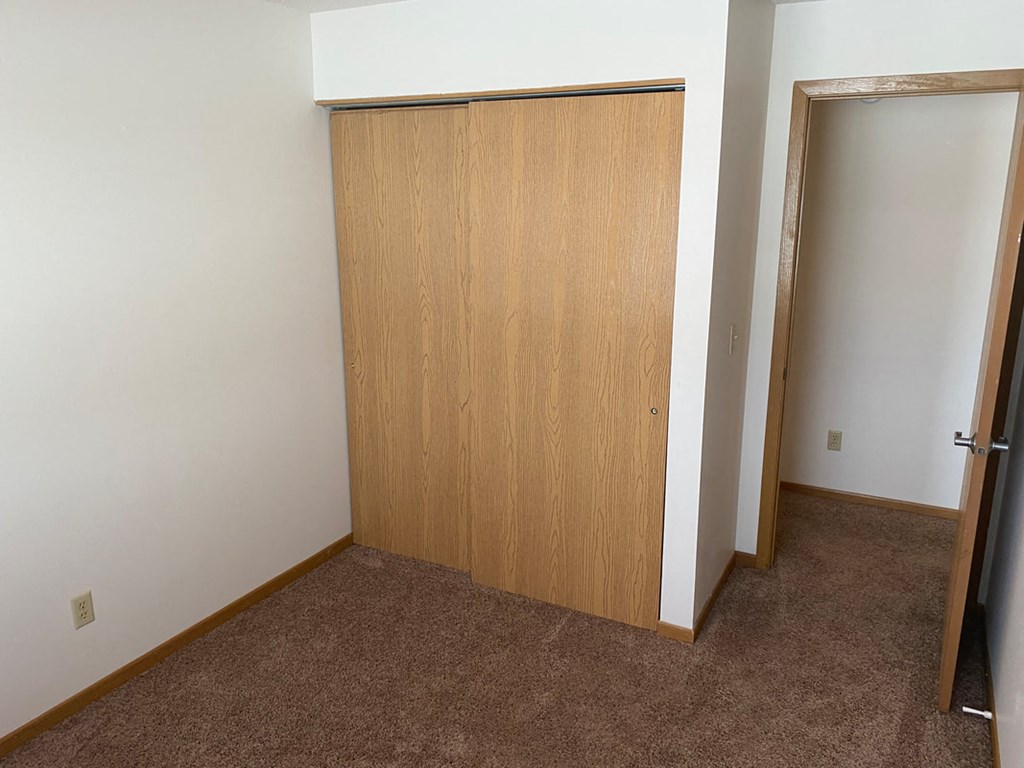 an empty room with a closet and a door