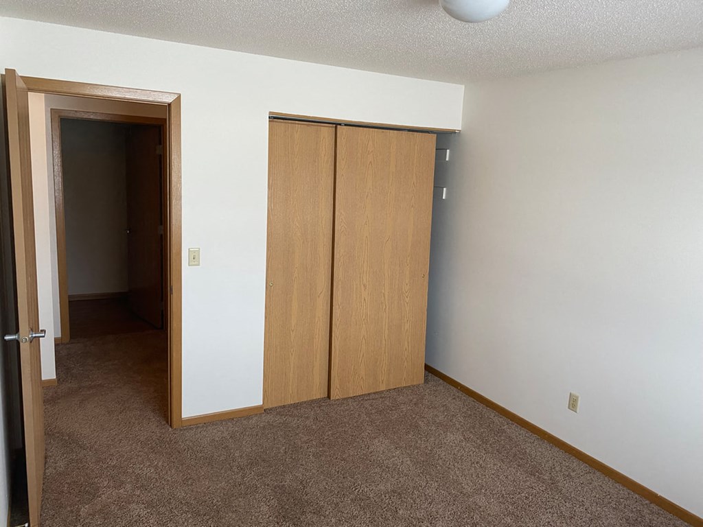 a bedroom with a door to a closet and an open door