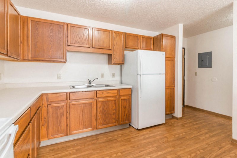 a kitchen with wooden cabinets and a white refrigerator