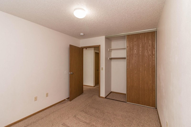 a bedroom with a closet and a door to a bathroom