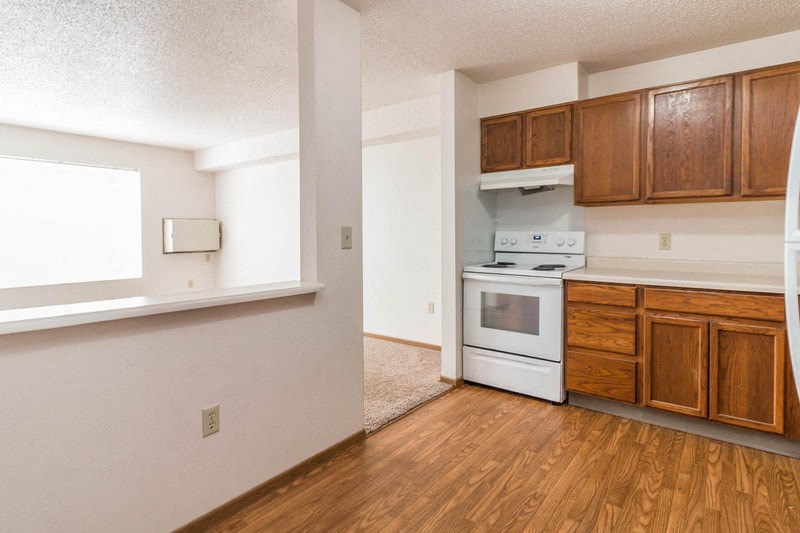 a kitchen with white appliances and wooden cabinets