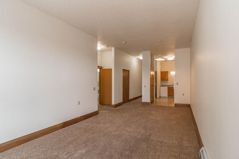 an empty living room with carpet and white walls