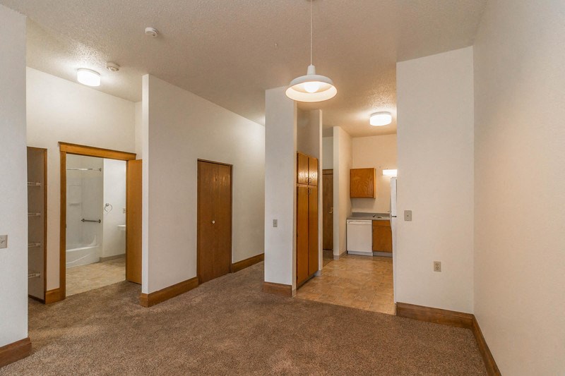 an empty living room with a carpeted floor and white walls