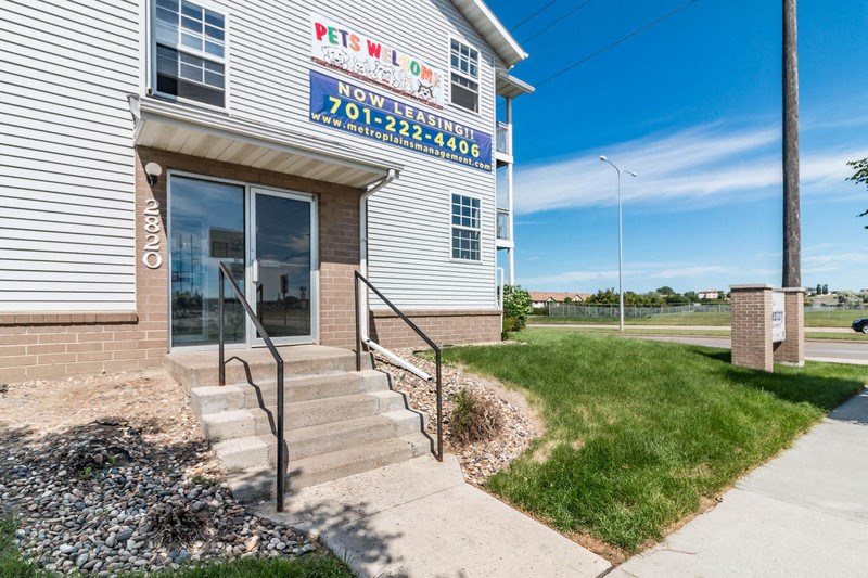 the front of a building with stairs and a sign for a pizza restaurant