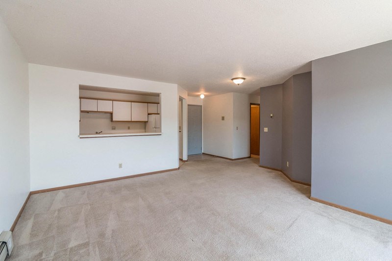 an empty living room and kitchen in a house