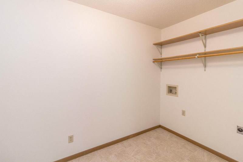 a room with a white wall and a hanging rack on the wall