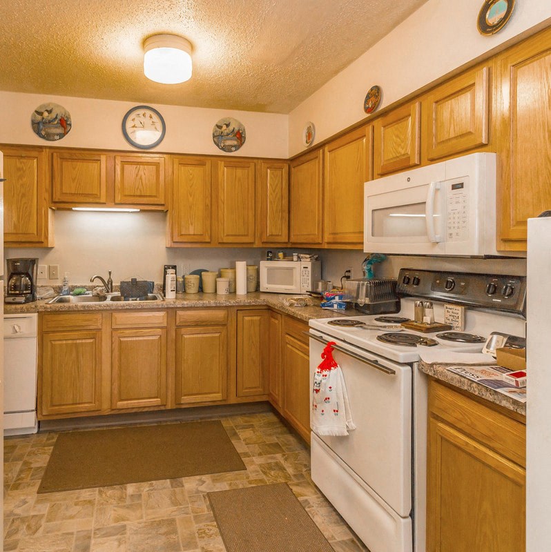 a kitchen with white appliances and wooden cabinets