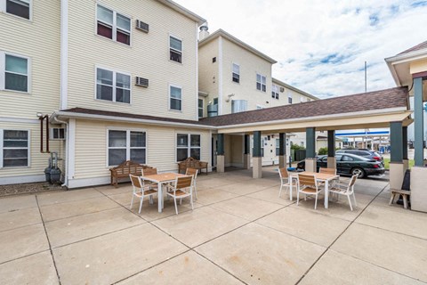 a patio with tables and chairs outside of a building