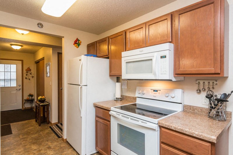 a kitchen with white appliances and wooden cabinets