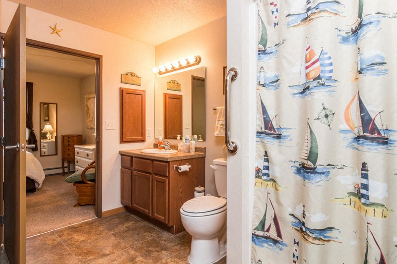 a bathroom with a shower curtain and a toilet and a sink