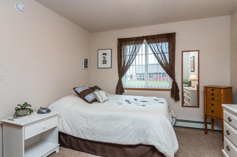 a bedroom with a bed and a window