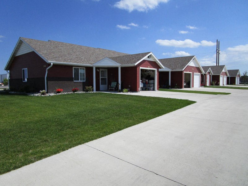 a group of houses in a row with a sidewalk and grass