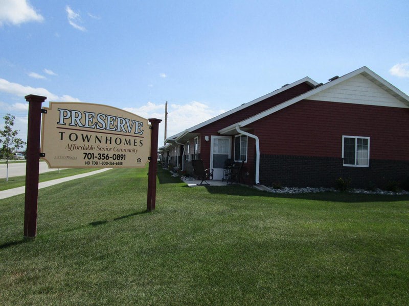 a sign that reads preserve town homes in front of a building