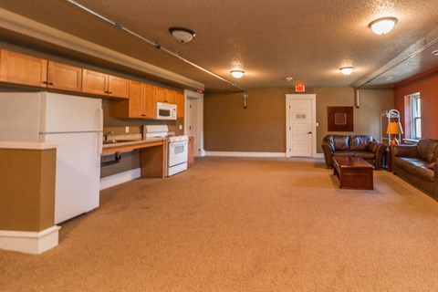 A kitchen with brown carpeting and white appliances.