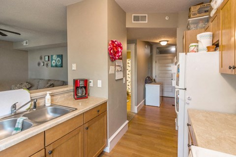 A kitchen with a sink, a refrigerator, and a counter.