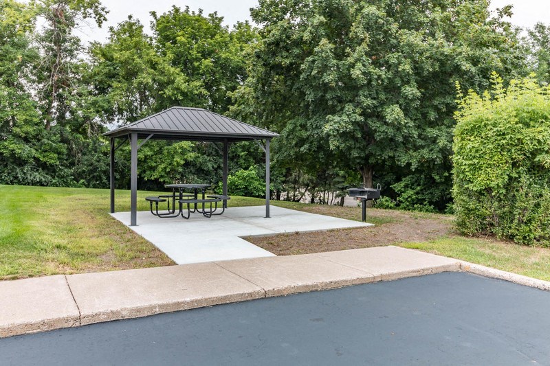 a picnic area with a picnic table and a gazebo in a park
