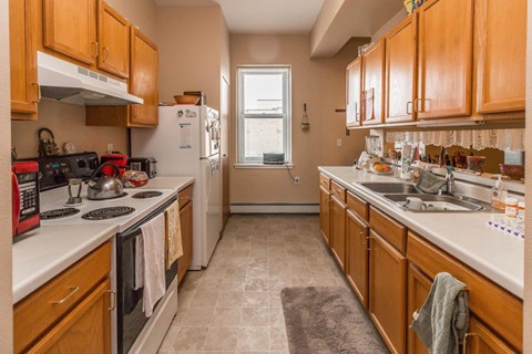A kitchen with wooden cabinets and a white counter top.