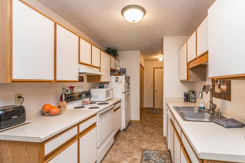 a kitchen with white appliances and wooden cabinets