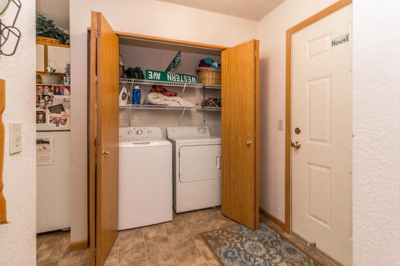 the laundry room has a washer and dryer and a closet with shelves