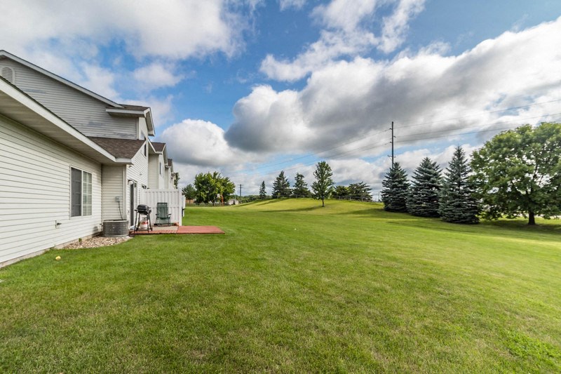 the backyard of a house with a lawn and a golf course