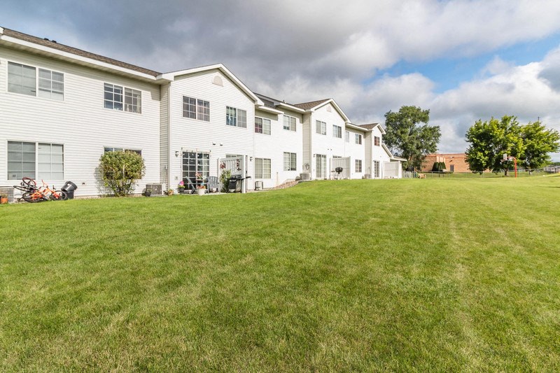 a large lawn in front of a row of houses