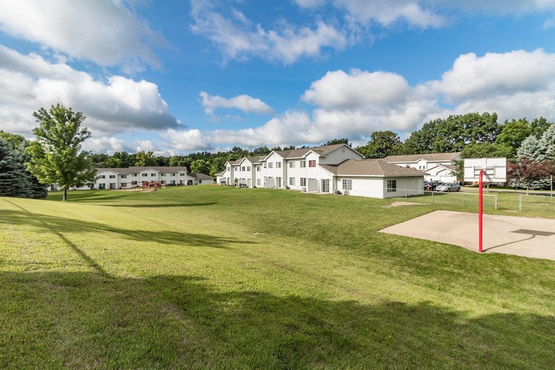 the view of a park with apartments in the background