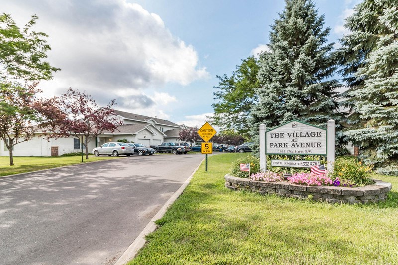 the village park avenue entrance sign on the side of a road