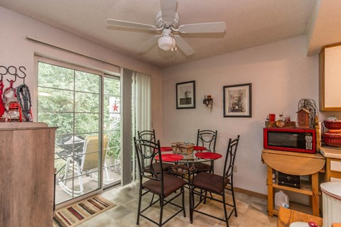 a dining room with a table and chairs and a ceiling fan