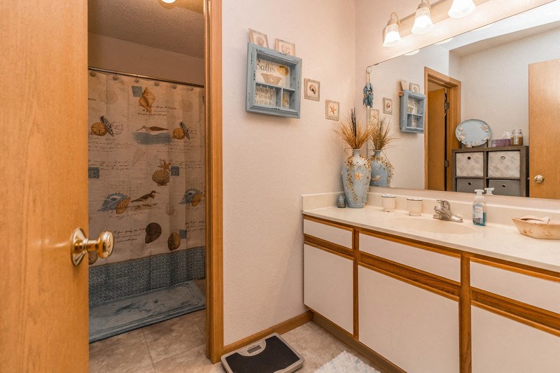 a bathroom with a sink and a shower and a mirror