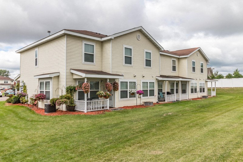 the front of a house with a lawn and a porch