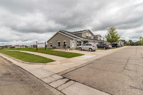 the front of a building with cars parked in front of it