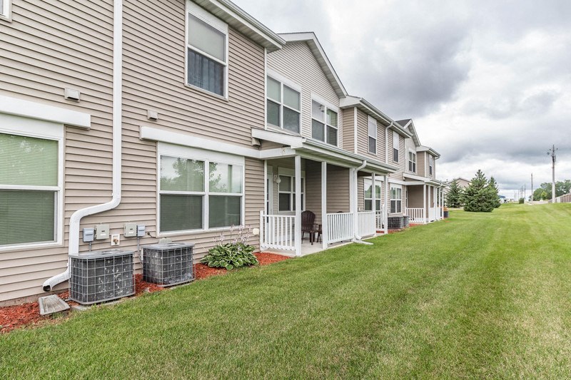 the outlook of the side of a house with a yard and grass