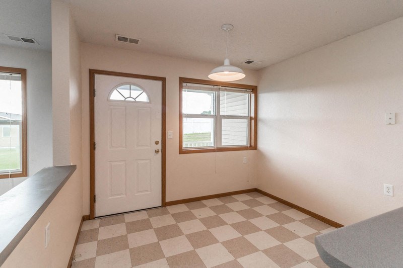 the living room of a house with a checkered floor and a white door