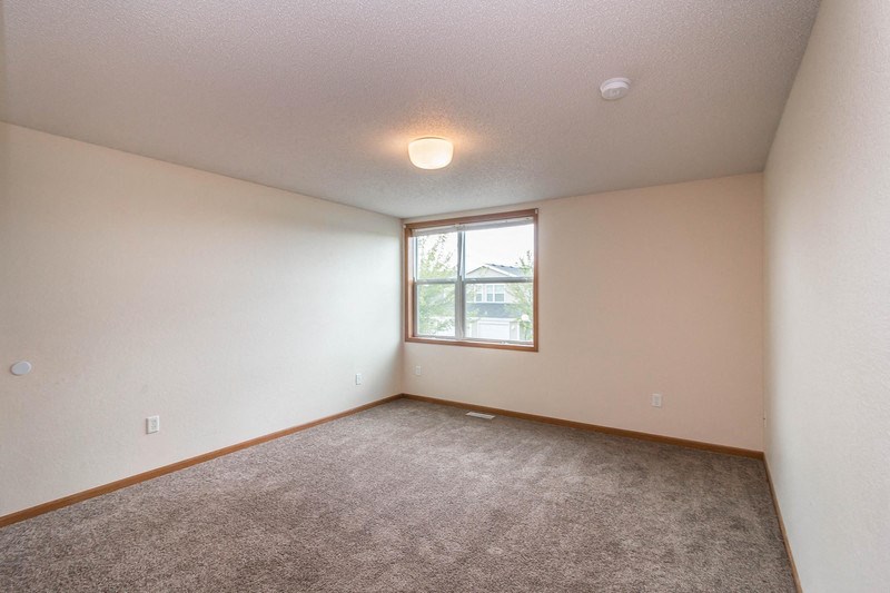 an empty living room with carpet and a window