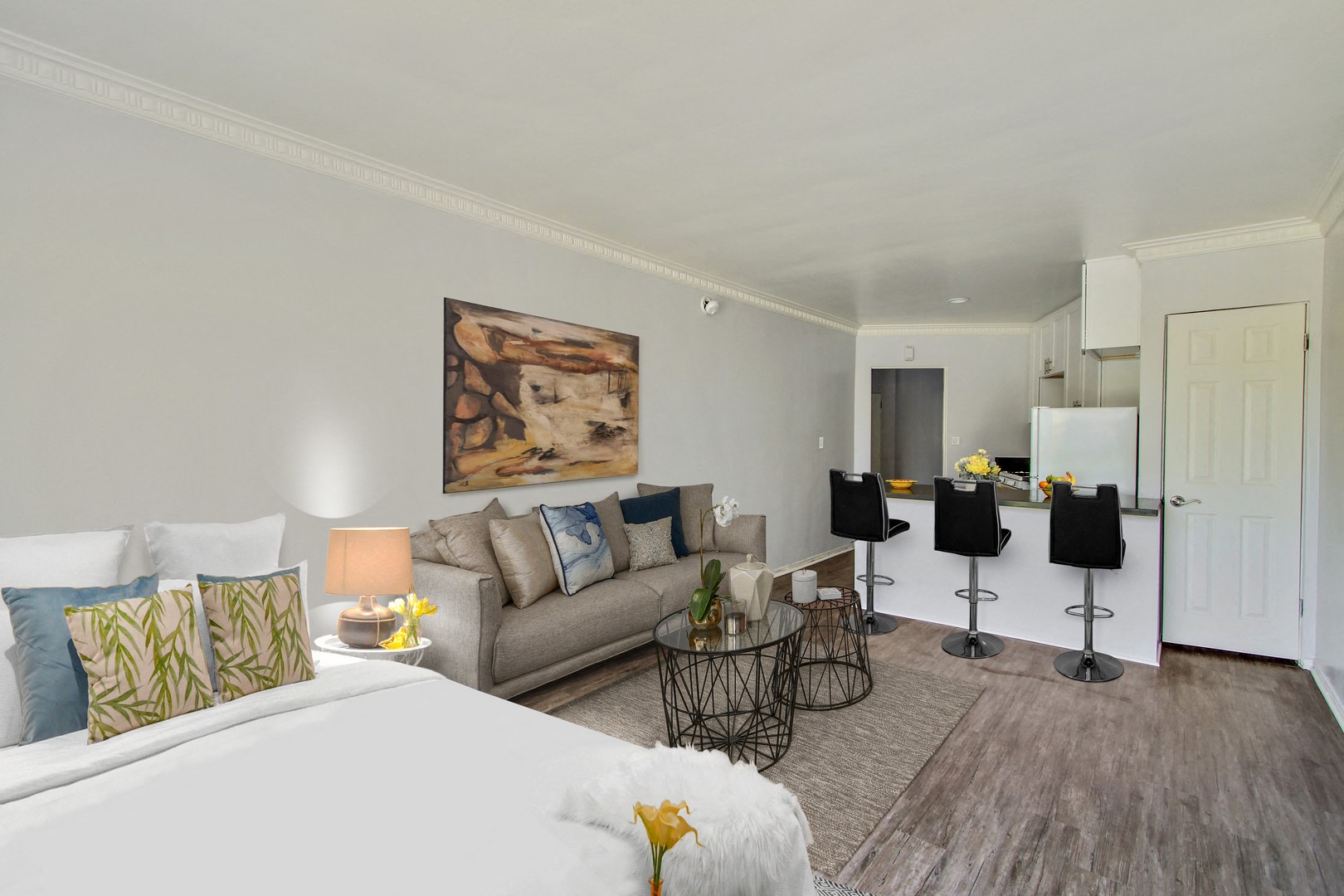 A bedroom with a large bed and a painting on the wall.