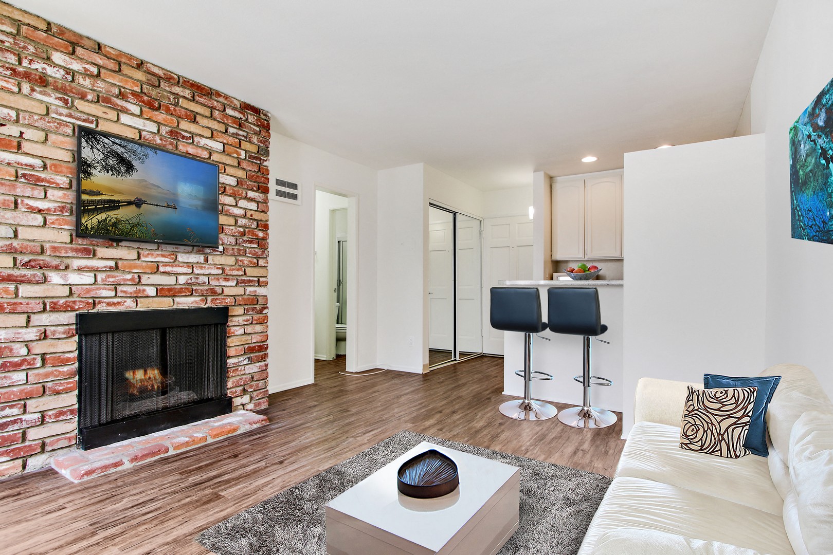 A living room with a fireplace and a painting on the wall.