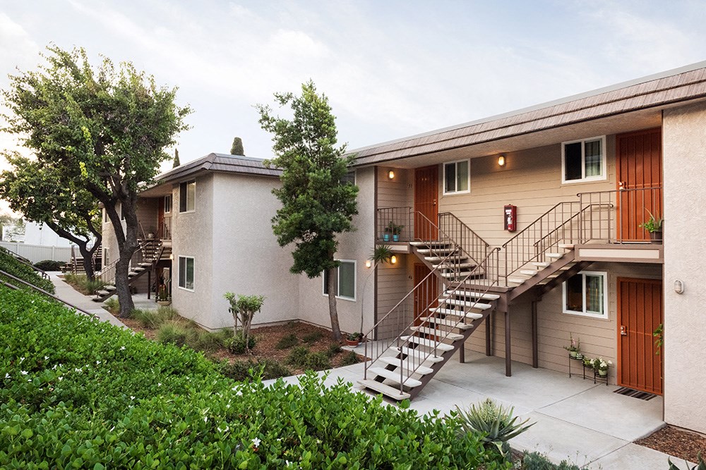 an apartment building with stairs and a stairway to a balcony
