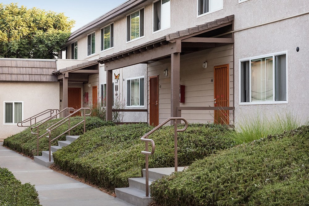 a building with stairs and a sidewalk in front of it