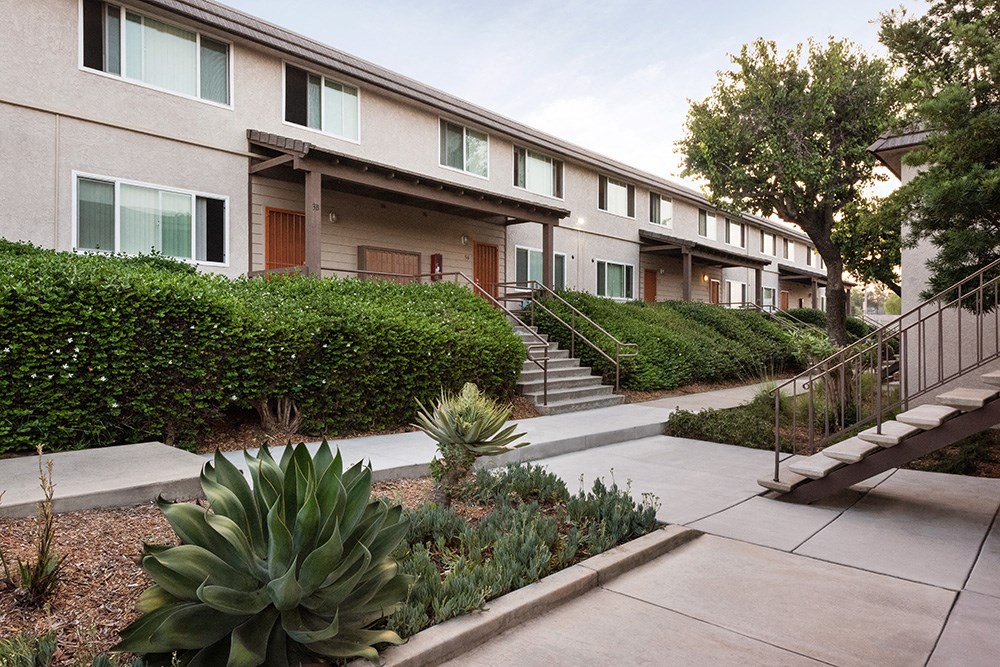 a sidewalk in front of a building with stairs