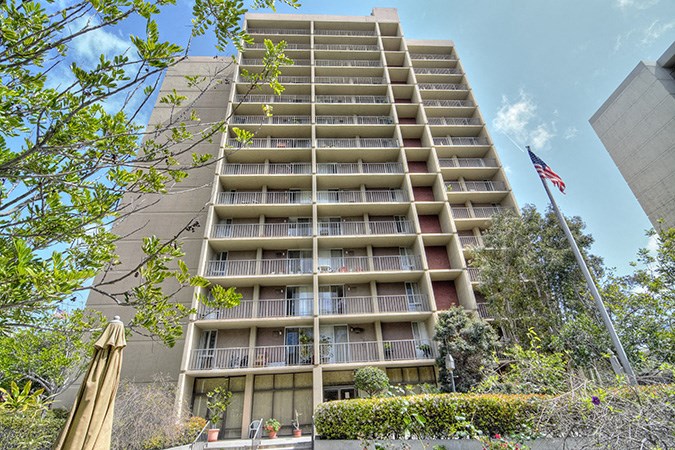 an apartment building with balconies and an flag