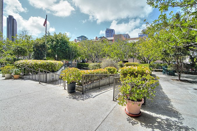 a park with flowers and trees and a fence