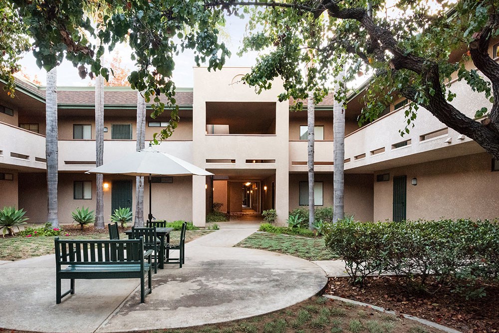 a courtyard with benches in front of a building