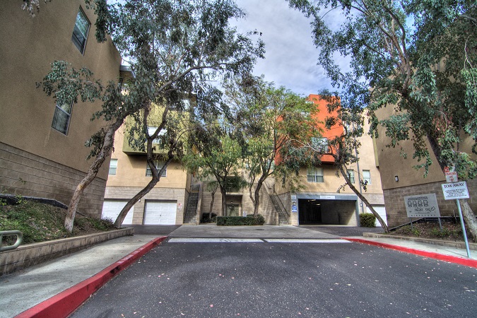 an empty parking lot in front of an apartment building